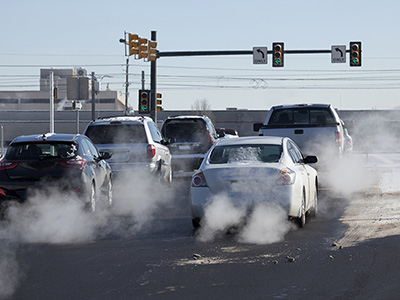 Cars stopped at a Colorado Springs intersection with winter conditions causing car paint damage.